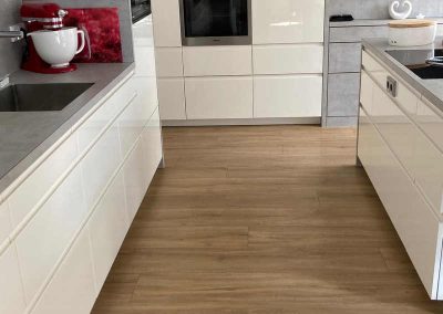 Moderne Küche mit DISANO-Designboden, der einen eleganten Bodenbelag aus hellen Holzoptiken präsentiert.