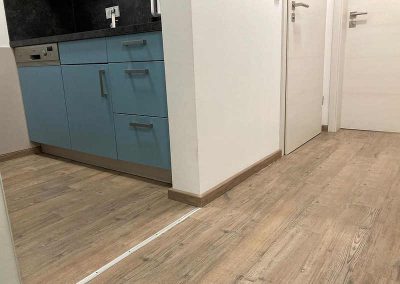 Eine moderne Küche mit Vinylboden, der elegant in den Raum integriert ist, schafft ein stilvolles Ambiente.